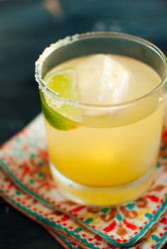 a close up of a drink on a napkin with a slice of lime in it