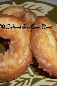 three glazed doughnuts sitting on top of a green and white plate with the words old fashioned sour cream donuts