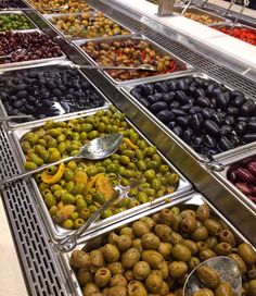 an assortment of olives and pickles on display in a grocery store or restaurant