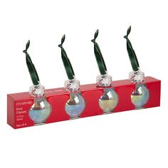 three glass vases with green stems in them sitting on a red box that says christmas