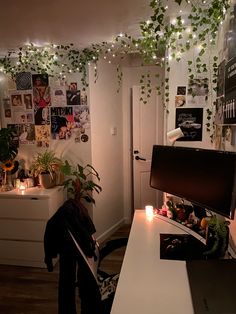 a living room filled with furniture and lots of greenery hanging from the ceiling above