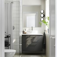 a bathroom with a sink, mirror and shower