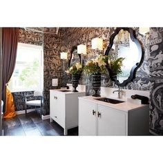 a bathroom with black and white wallpaper, two sinks and a mirror on the wall