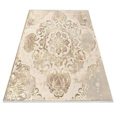 a white and gold area rug with an intricate design on the top, in front of a white background