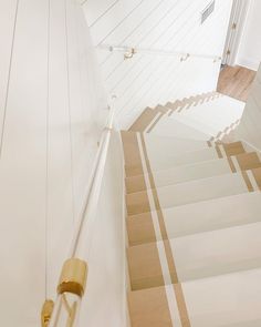 a stair case with white walls and wooden steps