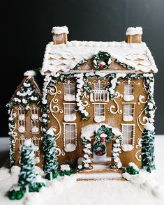 a gingerbread house with decorations on the roof and windows is shown in the snow