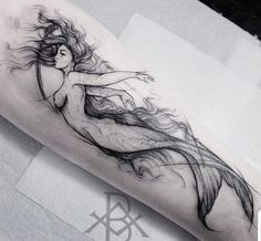 a woman's leg with a long flowing hair tattoo design on the right thigh