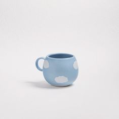 a blue cup with white polka dots on the inside is sitting in front of a white background