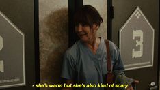 a woman standing in front of a door with the words she's warm but she's also kind of scary