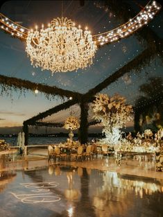 an indoor wedding venue with chandelier and tables