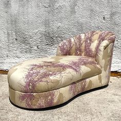 an upholstered chaise lounge sitting in front of a wall