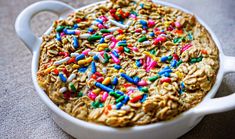 an oatmeal dish with sprinkles and cereal in it on a table