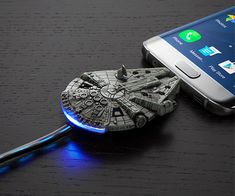 a cell phone with a blue light on it next to a darth vader keychain