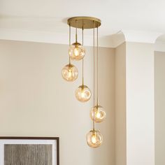 a chandelier with five lights hanging from it's sides in a living room