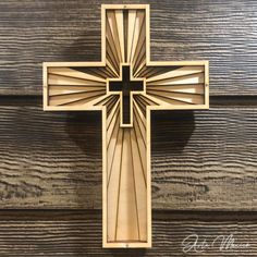 a wooden cross hanging from the side of a wall in front of a wood paneled door