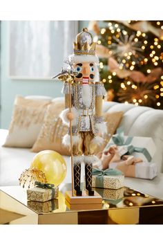 a nutcracker figurine on a table in front of a christmas tree