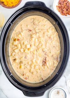 an overhead view of a crock pot filled with macaroni and cheese soup