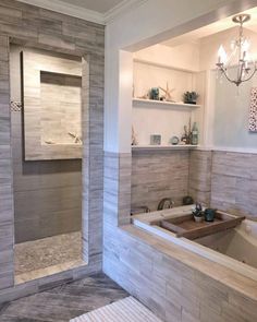 a bath room with a large tub and a chandelier hanging from the ceiling