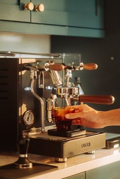 a person is making something from a coffee machine