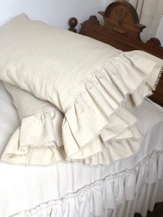 two pillows on top of a bed with ruffled edges