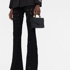 “Cut-Out Flared Trousers Made In Italy And Designed For A Stretch Fit, These Black Trousers From Versace Sit High At The Waist For An Elongating Silhouette And Fall Into A Flared Leg Punctuated With Slash Cut-Out Details - A Nod To The House's Bold Take On Understated Designs. Made In Italy Composition Viscose 82%, Polyester 17%, Elastane 1% Washing Instructions Dry Clean Only Wearing The Model Is 5 Ft 11 In Wearing Size 40 The Model Is Also Styled With: Versace Single-Breasted Wool Blazer, Amin Versace Pants, Versace Pink, Leather Mini Bag, Suede Pants, Vintage Versace, Flared Trousers, Black Houndstooth, Flare Trousers, Black Trousers