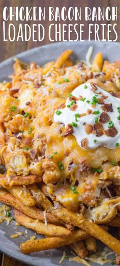 chicken bacon ranch loaded cheese fries on a gray plate with sour cream and chives