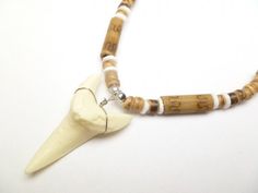 Necklace Length:  Approx. 18 inches Bone Powder Shark Tooth Length: Approx. 1.5 inches Each piece has a distinct character of its own, for no two are exactly alike in color, shape, and size. Hand-crafted, sanded and polished by Native artisans Themed White Necklaces For Gifts, Nickel-free White Necklace With Round Beads, White Nickel-free Necklace With Round Beads, Adjustable Themed Necklace For Collectors, Personalized Themed White Necklace, Themed Personalized White Necklace, White Personalized Novelty Jewelry, Novelty Personalized White Jewelry, Personalized White Novelty Jewelry