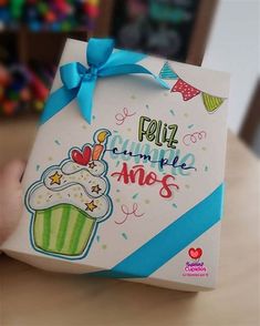 a hand holding up a birthday card with a cupcake on it and the words, feliz cumple amis