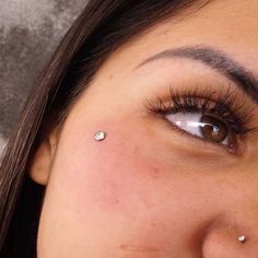 a woman with piercings on her nose looking at the camera