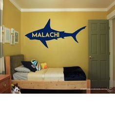 a bedroom with a bed and a shark decal on the wall