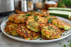 there is a plate full of zucchini fritters on the table