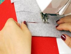 a woman is using a sewing machine to sew something on the side of a piece of fabric