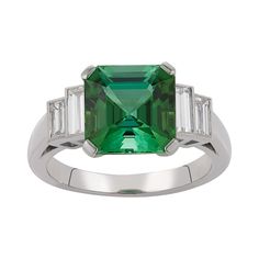 E Wolfe & Company Handmade 18ct White Gold Green Tourmaline and Diamond Baguette Ring. The green tourmaline centre stone weighs 3.59 carats and has two pairs of baguettes diamonds set to either side. The baguette diamonds have a total weight of .73 carats and are of G colour and VS clarity. The ring was handmade at our London Workshop during 2021 and it weighs 5.14 grams. Currently the ring is a British finger size K 1/2 but it can be increased or reduced in size as is required. Elegant Green Gemstones In Platinum Setting, Green Platinum Gemstones Fine Jewelry, Elegant Green Gemstones In Platinum, Fine Green Platinum Gemstones Jewelry, Classic Green Tourmaline Jewelry, Luxury Green Octagon Rings, Elegant Green Platinum Gemstones, Modern Green Emerald Ring With Accent Stones, Luxury Emerald Ring With Baguette Cut And Accent Stones