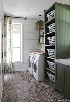 a washer and dryer in a small room with green cabinetry, window, and brick floor