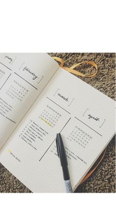 an open planner with a pen on top of it