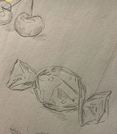 some fruit are sitting on top of a piece of paper with pencils and ink