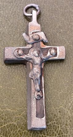 an old metal cross with a cow head on it's side and a chain hanging from the end