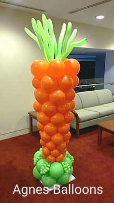 an inflatable carrot plant with green leaves and oranges on it's head