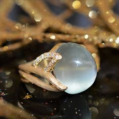 A ladies 18 karat yellow gold moonstone and diamond ring signed and numbered by designer Henry Dunay.  The pastel green moonstone weighs 15.29 carats and there are 30 round diamonds having a total weight of .26 carats. Yellow Gold Moonstone Ring With Gemstone Accents, Luxury Yellow Gold Diamond Moonstone Ring, Luxury Moonstone Ring With Accent Stones, Luxury Round Moonstone Gemstone Ring, Luxury Moonstone Ring With Gemstone Accents For Gift, Luxury Moonstone Ring With Rose Cut Diamonds, Luxury Cabochon Moonstone Ring Gift, Luxury Moonstone Cabochon Ring As Gift, Luxury Gift Moonstone Cabochon Ring