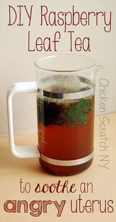 a glass pitcher filled with tea sitting on top of a table