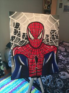 a spiderman painting on a canvas sitting on top of a bed