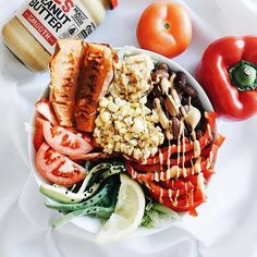 a salad with tomatoes, lettuce, corn and dressing