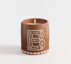 a candle that is sitting in front of a white background with the letter b on it