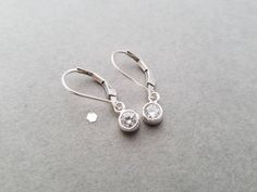 "These tiny sterling silver earrings earrings are small, simple and great for every day wear! A crystal clear CZ circle measuring aprox 5mm hangs from sterling silver leverback or french earwires. The total length of these earrings is almost 1\". Earrings will arrive in a small zip lock bag. It is recommended that the earrings are kept in the bag when not being worn to keep them nice and shiny. Of course, a quick polish will always work too :-) Please let me know if you have any questions!" Silver Round Cut Earrings With Lever Back Ear Wires, Silver Round Cut Earrings With Lever Back, Classic Silver Lever Back Earrings, Silver Round Earrings With Lever Back, Silver Round Lever Back Earrings, Round Silver Lever Back Earrings, Zip Lock Bag, Earrings Round, Silver Bow