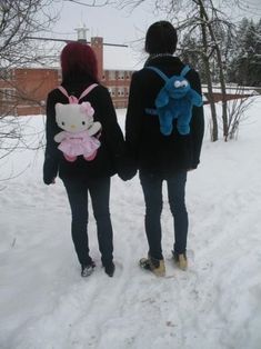 two people walking in the snow with hello kitty backpacks