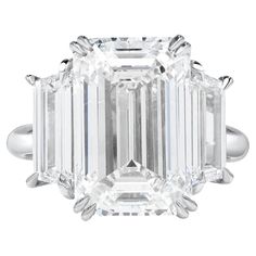 an emerald - cut diamond ring with three baguets on the shoulders and sides