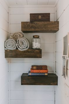 two wooden shelves with towels and books on them