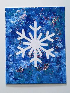 a piece of art that has been made to look like a snowflake on blue paper