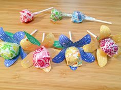 several colorful candy lollipops sitting on top of a wooden table