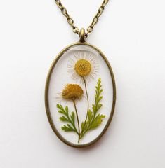 An unique handmade real pressed flower resin necklace. Do you love nature but too busy to get a real touch of it? Then this is the perfect piece of real flower necklace to reconnect you to mother nature! This necklace is created with pressed real wild daisy twig and lace fern leaves! Beautiful floral gifts of mother nature were carefully handcrafted to create unique design and embedded into high quality resin to provide everlasting value! Now set yourself free from the boredom of artificial urba Nature-inspired Flower Necklace With Round Pendant, Nature-inspired Birth Flower Pendant Necklace, Nature-inspired Birth Flower Round Pendant Necklace, Nature-inspired Round Pendant Flower Necklace, Handmade Flower Pendant Nature Necklace, Handmade Resin Necklaces With Nature-inspired Style, Botanical Flower Jewelry With Pressed Flowers, Handmade Nature-inspired Flower Pendant Necklace, Nature-inspired Flower Jewelry With Pressed Flowers